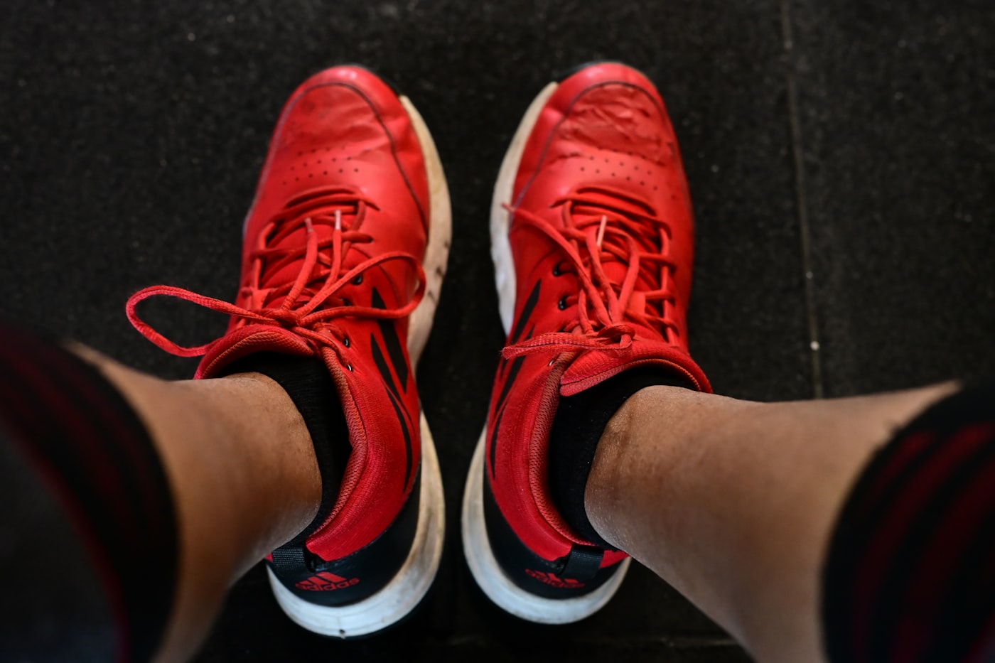 Close up of red athletic shoes with white soles used for functional fitness training